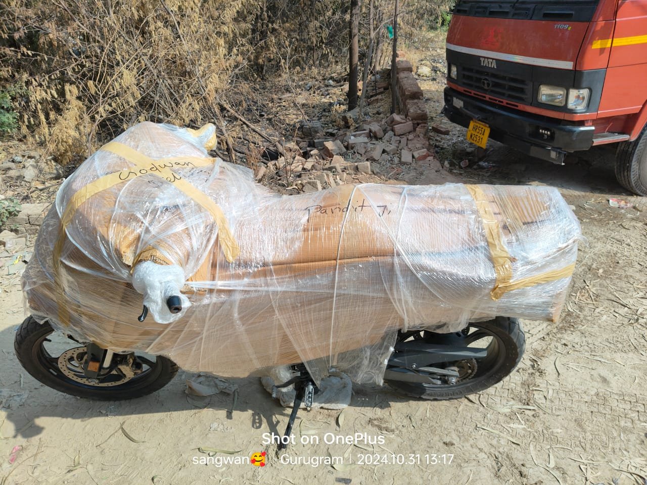 Motorcycle fully wrapped in corrugated sheet and stretch film before loading