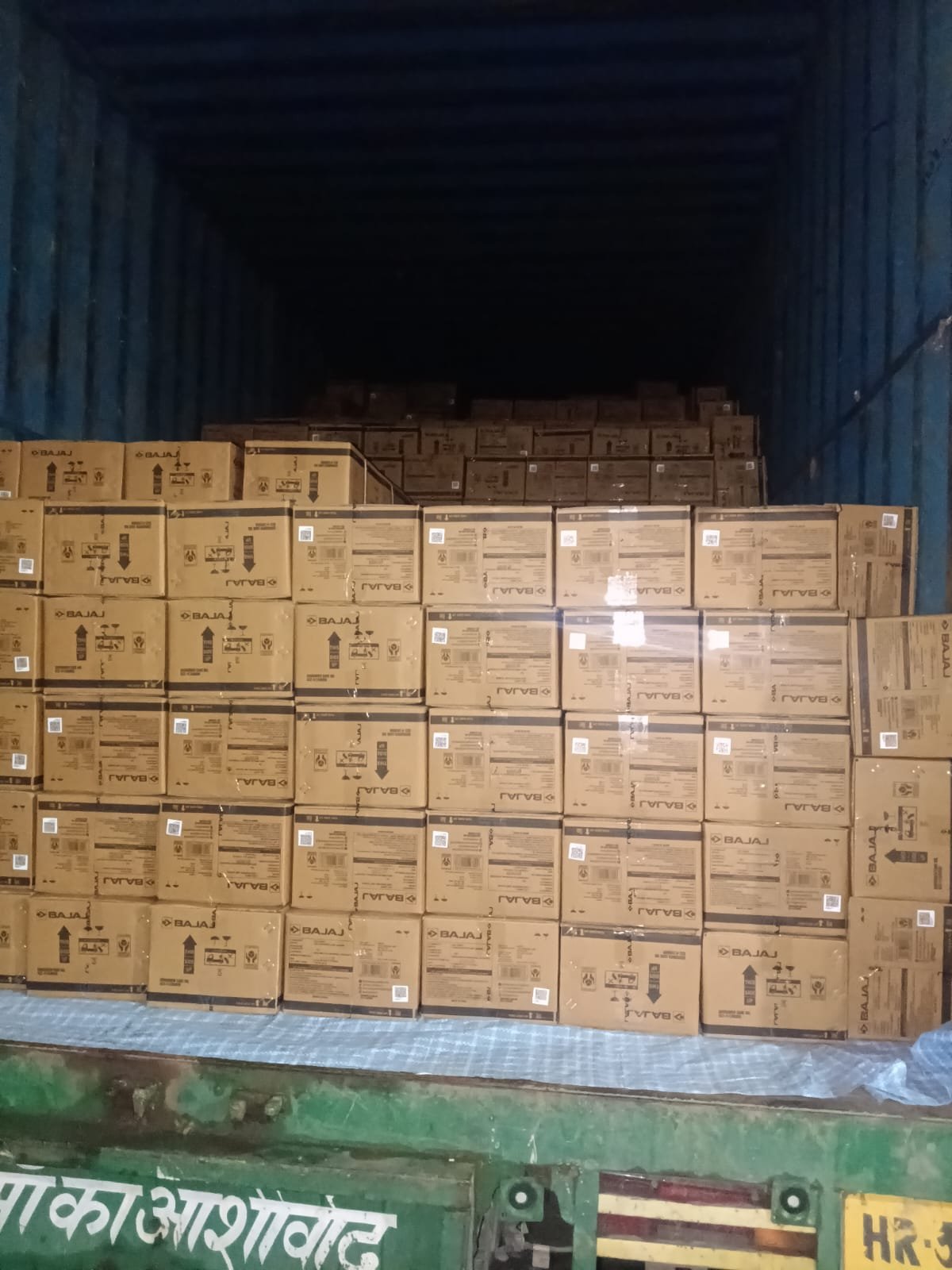 Uniform packed cartons stacked floor to ceiling inside a shipping container